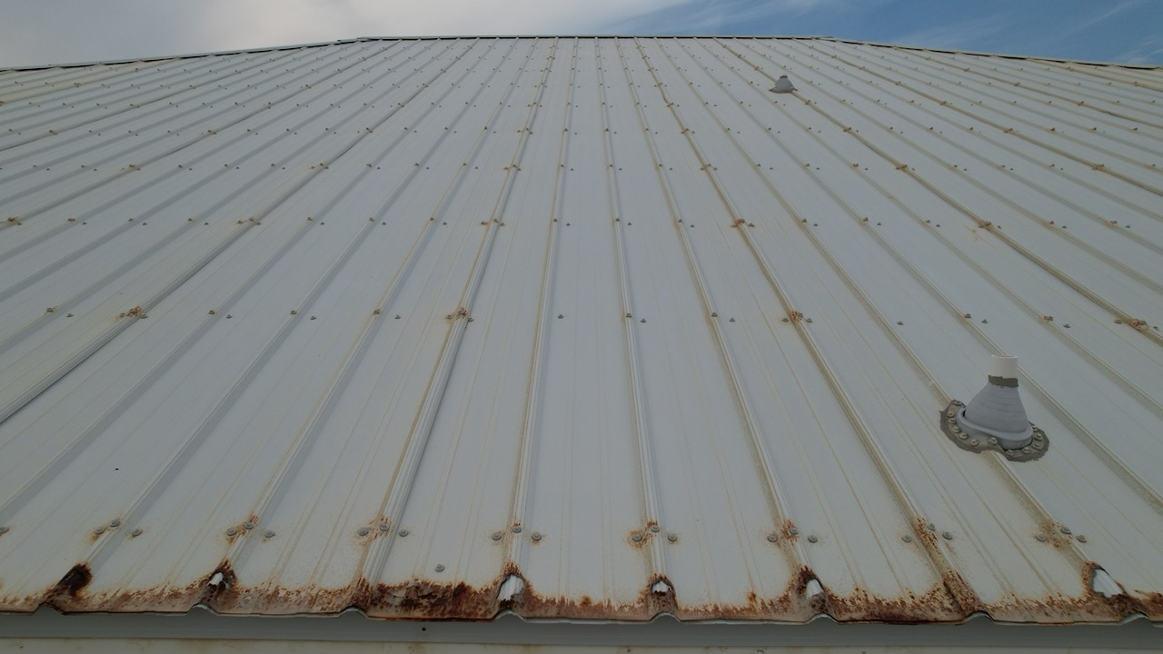 image of holes in discolored metal roof