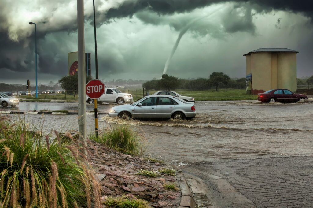 image of tornado approaching cars on a flooded road